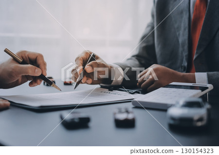 Car salesman gave the keys to the customers who signed the purchase contract legally, Successful completion of car sales, Purchase contract and key delivery. 130154323