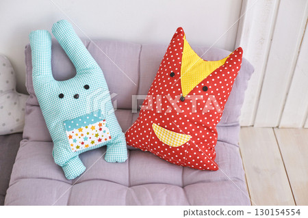 Cute patchwork plush toys on sofa with light purple cushion background Cute patchwork plush toys on sofa with light purple cushion background 130154554
