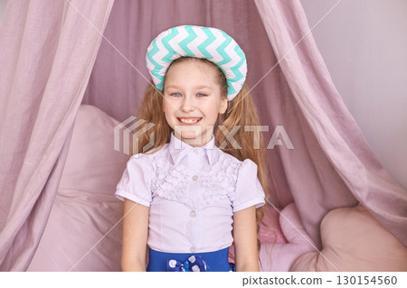 Caucasian female child smiling in bedroom with canopy and decorative chevron Caucasian female child smiling in bedroom with canopy and decorative chevron 130154560