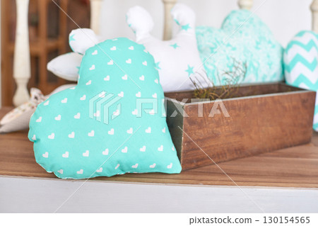 Decorative heart-shaped pillow with white polka dots on rustic wooden table 130154565