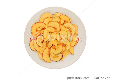 Dried apples in a white ceramic plate isolated on a white background. Various dry slices of fruits. Homemade preparation of snack. Top view. 130154736