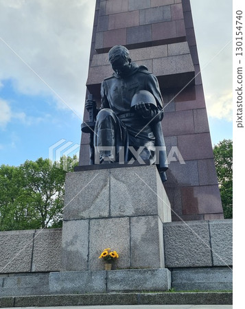 Berlin, Germany - August 1, 2025: Bronze statue of a kneeling Soviet soldier in Treptower Park at the Soviet War Memorial Berlin, Germany - August 1, 2025: Bronze statue of a kneeling Soviet soldier in Treptower Park at the Soviet War Memorial 130154740