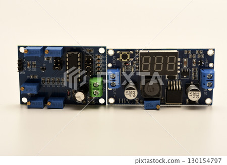 Two electronic devices on a blue printed circuit board. A small electronic device. Two electronic devices on a blue printed circuit board. A small electronic device. 130154797