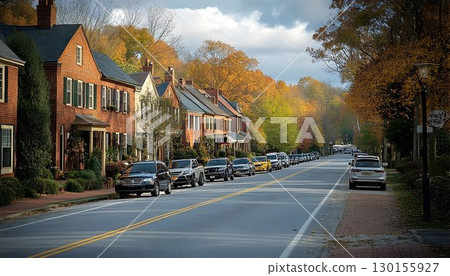 Autumn serenity: A picturesque street with cars parked beneath vibrant foliage 130155927