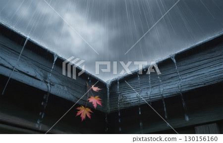 Low angle view of heavy rain falling on a dark wooden eave with autumn leaves 130156160