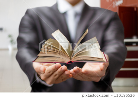 Presenting knowledge with a book in a professional setting. Presenting knowledge with a book in a professional setting. 130156526