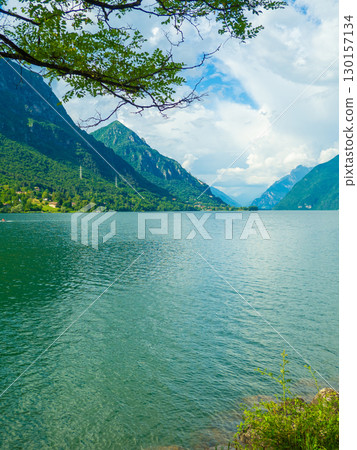 Serene Lake Idro Surrounded by Majestic Mountains and Cloudy sky, Italy, Crone Serene Lake Idro Surrounded by Majestic Mountains and Cloudy sky, Italy, Crone 130157134