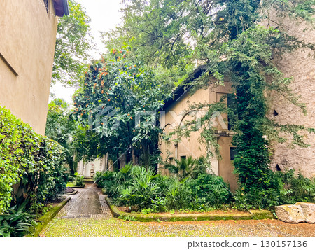 Courtyard with lush vegetation and a statue of a flamingo in the background Courtyard with lush vegetation and a statue of a flamingo in the background 130157136