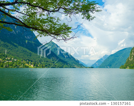 Serene Lake Idro Surrounded by Majestic Mountains and Cloudy sky, Italy, Crone Serene Lake Idro Surrounded by Majestic Mountains and Cloudy sky, Italy, Crone 130157161