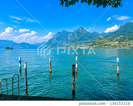 View of Iseo Lake Surrounded by Majestic Mountains and Clear Blue Skies, Italy View of Iseo Lake Surrounded by Majestic Mountains and Clear Blue Skies, Italy 130157218
