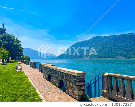 View of Iseo Lake Surrounded by Majestic Mountains and Clear Blue Skies, Italy View of Iseo Lake Surrounded by Majestic Mountains and Clear Blue Skies, Italy 130157227