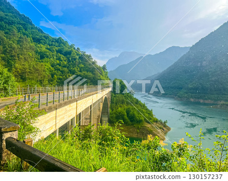 Valvestino lake and Recchi bridge on summer rainy day, Italy Valvestino lake and Recchi bridge on summer rainy day, Italy 130157237
