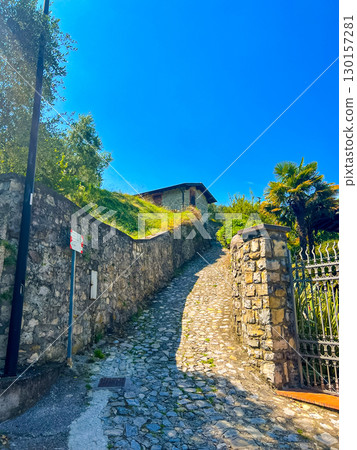 Picturesque stone road leading along a historic fence in carzano, italy 130157281