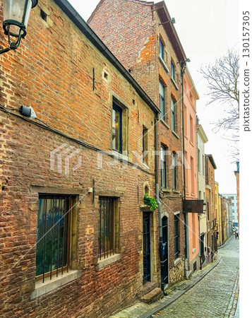 Old brick building facade in brussels with cobblestone street view Old brick building facade in brussels with cobblestone street view 130157305