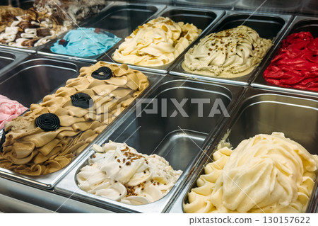 Bright assortment of gelato in multiple flavors including licorice, pistachio, vanilla, and berry in a display freezer. Artisanal desserts, gelato, flavor experimentation, local sweet traditions 130157622