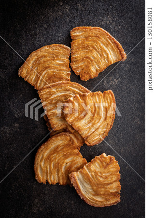 Le sfoglie. Crispy sweet pastry on black table. Top view. Le sfoglie. Crispy sweet pastry on black table. Top view. 130158081