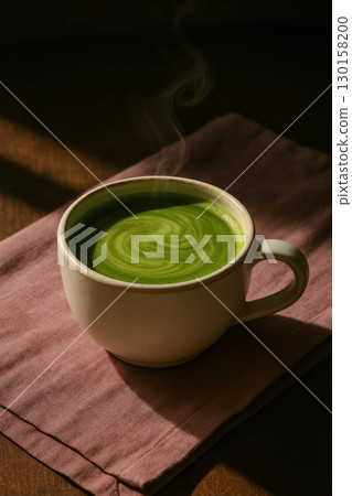 Steaming matcha latte in white cup on pink linen moody shadows rustic breakfast setting with warm sunlight and cozy atmosphere 130158200