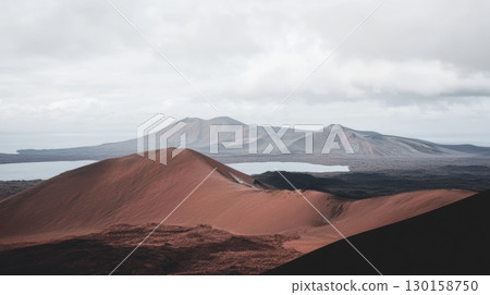 Breathtaking volcanic landscape at sunset with distant mountains and a calm lake 130158750