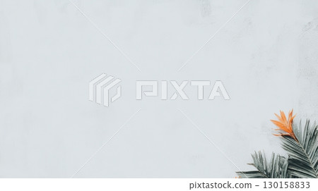 Tropical leaf arrangement with vibrant orange flower against a soft pastel background in an artistic setting 130158833