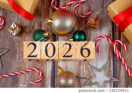 Wooden blocks with 2026 and Christmas decorations on rustic table. golden and green baubles, candy canes 130159051