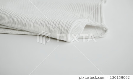 Soft white fabric neatly folded on a smooth surface in a well-lit room 130159062