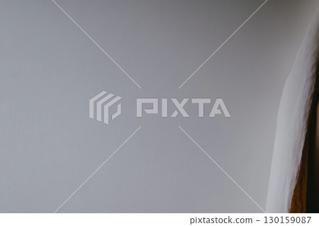 Soft gray wall with subtle light reflections and shadow play in an indoor space during the day 130159087