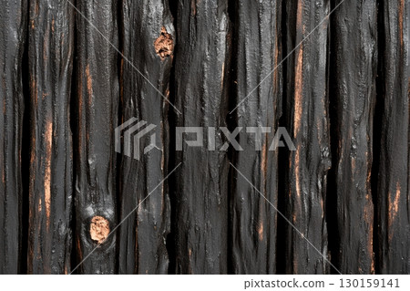 Wooden texture featuring dark, weathered planks with visible knots captured in natural light 130159141