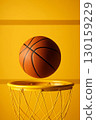 Basketball flying above yellow hoop on vibrant background. Ideal for fitness, teamwork and youth themes. 130159229