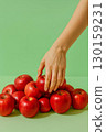 Hand picking red apple from pile of fruits on green background Minimalist food concept. Healthy eating, . 130159231