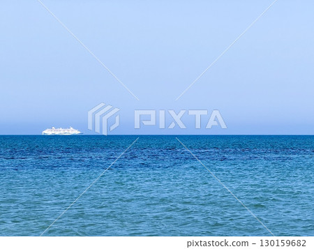 Picturesque beach, waves crashing on the sandy shore. Sea waves beat against the rocks. Cyprus Island, umbrellas, tourist boats, Mediterranean Sea. 130159682