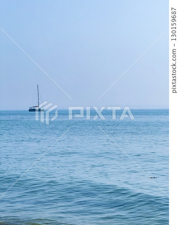 Picturesque beach, waves crashing on the sandy shore. Sea waves beat against the rocks. Cyprus Island, umbrellas, tourist boats, Mediterranean Sea. Picturesque beach, waves crashing on the sandy shore. Sea waves beat against the rocks. Cyprus Island, umbrellas, tourist boats, Mediterranean Sea. 130159687