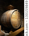 A historic wine cellar with an antique wooden press, grape crusher, and giant barrel. The concept is traditional winemaking heritage and craftsmanship. 130159849