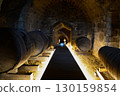 A historic wine cellar with an antique wooden press, grape crusher, and giant barrel. The concept is traditional winemaking heritage and craftsmanship. 130159854