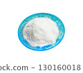 Stylish green salt shaker with patterns with a heap of salt on a white background 130160018
