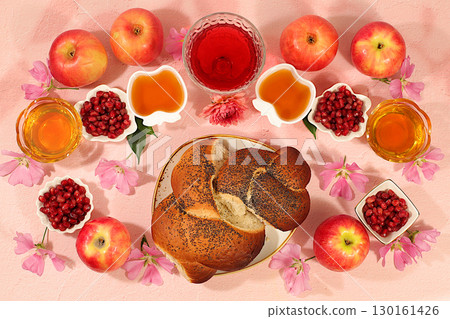 Jewish holiday Rosh Hashanah concept with apples, honey, pomegranate, flowers, red wine and Challah bread for greeting card, creative mockup and template for Jewish New Year and Thanksgiving, Jewish holiday Rosh Hashanah concept with apples, honey, pomegranate, flowers, red wine and Challah bread for greeting card, creative mockup and template for Jewish New Year and Thanksgiving, 130161426