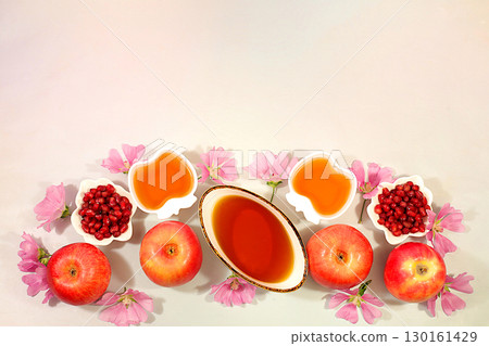 Creative composition for the Jewish holiday Ro Hashanah with a place for congratulations. Layout with traditional symbols of the Jewish New Year, template with honey, apples, pomegranate and flowers 130161429