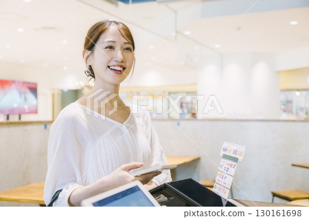 一位女士在咖啡館收銀台進行無現金支付 130161698