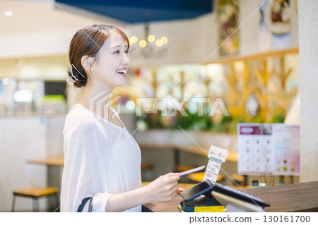 女性透過卡片、收銀機、無現金支付付款 女性透過卡片、收銀機、無現金支付付款 130161700