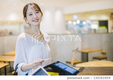 Woman paying by card, cash register, cashless payment 130161959