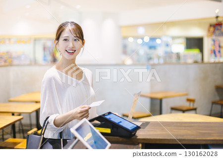 一位女士在咖啡館收銀台進行無現金支付 130162028