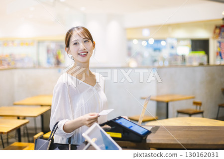一位女士在咖啡館收銀台進行無現金支付 130162031