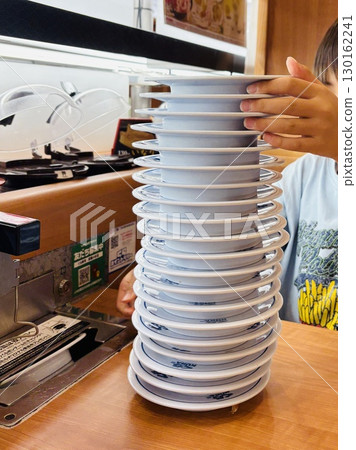 Sushi plates piled high 130162241