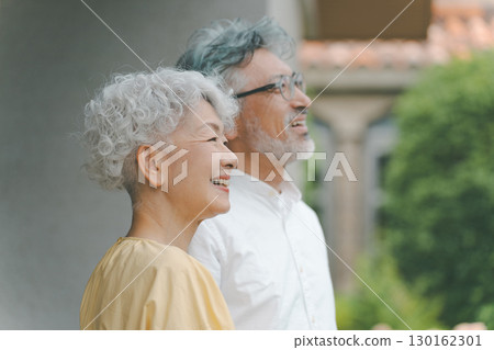 Senior couple looking at their garden Senior couple looking at their garden 130162301