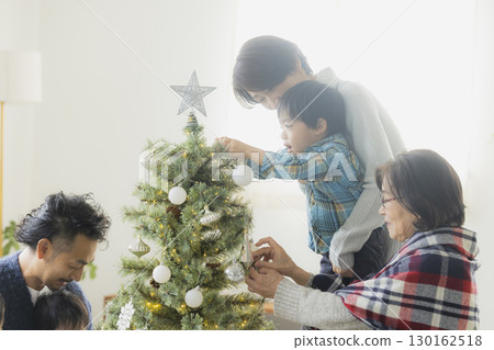 Families decorating Christmas trees 130162518