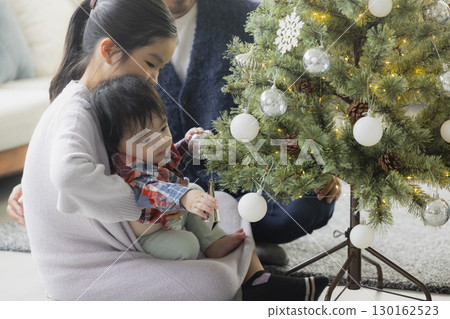 Families decorating Christmas trees 130162523