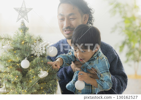 Families decorating Christmas trees Families decorating Christmas trees 130162527
