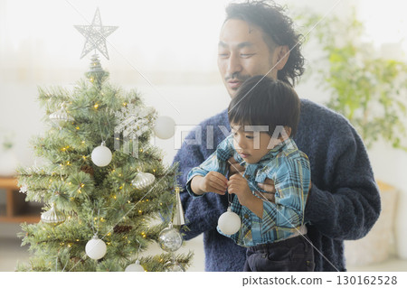 Families decorating Christmas trees 130162528