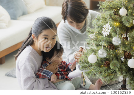 Families decorating Christmas trees 130162529