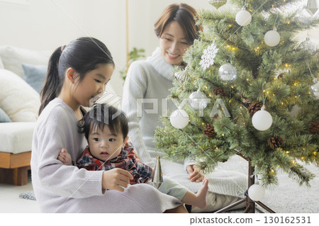 Families decorating Christmas trees 130162531