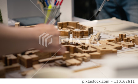 Close up of developers team sharing construction details in a briefing session, analyzing advanced architectural software and 3D models for a modern structural housing project. 130162611
